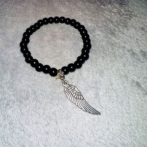 Black bracelet with half wing pendant